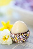 A marzipan egg with chocolate glaze and sugar sprinkles for Easter