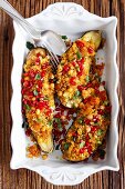 Aubergines filled with couscous, harissa, apricots, chickpeas and pomegranate seeds