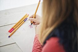 Girl writing numbers on stickers