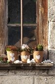 Winter planters hand-decorated with heart motifs on windowsill