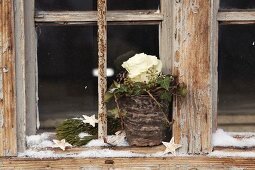 Plant pot dribbled with wax and decorated with rose, ivy and pine cones