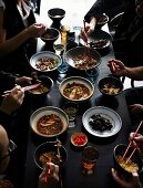 Eating people at a set table with various Chinese dishes