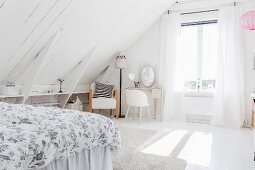 White wood-clad sloping ceiling, shelves fitted in knee wall, dressing table and rug in bright attic room