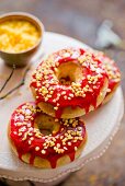 Donuts mit roter Zuckerglasur und Nusskrokant