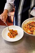 Chef serving Pasta with pancetta and sausage