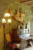 Piano and Baroque armchair against stone wall