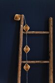 Fairy lights hung on wooden ladder against blue wall