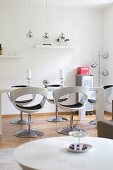 Glossy, white shell chairs in modern, white dining room