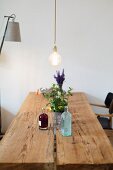 Pendant lamp above rustic dining table made from two old boards