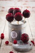 Cake pops with raspberries in a metal tin