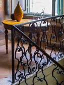 Wrought iron balustrade and antique wooden table in palazzo with terracotta floor