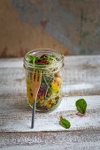 Wild herb salad with mango sauce in a jar
