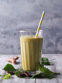 A smoothie made from leaves, oranges, pecan nuts and turmeric