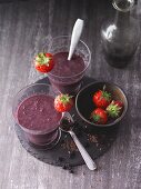 Strawberry and aronia berry smoothies with figs, flaxseeds and barley grass