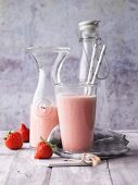 A strawberry and banana smoothie with coconut mousse, pistachios and yacon syrup