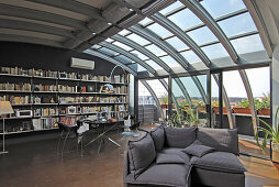 Bücherwand, Essbereich und Lounge in offenem Wohnraum mit Metall- und Glaselementen