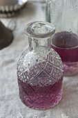 Homemade violet syrup in a carafe