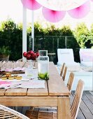 Pink lanterns on summer terrace with wooden table