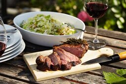 Grilled sirloin with a cabbage salad on a garden table