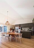Familie in offener Küche mit Esstisch und Parkettboden