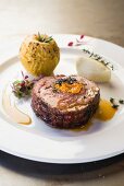 A pork collar steak filled with dried plums and blue cheese and served with a baked apple