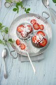Chocolate muffins with strawberry jam and icing sugar
