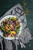 Winter salad with green and red cabbage, oranges, onions and walnuts