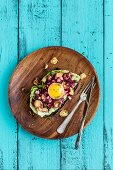 An open sandwich with a beetroot and mushroom salad and a raw egg yolk