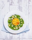 Baked eggs on pea and mint salad with feta cheese (England)