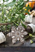 Sprigs of mistletoe in metal basket and snowflake biscuit (festive)