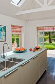Island counter under exposed roof structure in modern kitchen