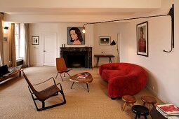 Red sofa, wall-mounted lamp and fireplace in living room