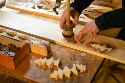 Tree silhouettes being transferred onto wood with woodstain and template