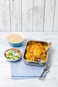 Lemon chicken in a roasting tin with rice and cucumber salad