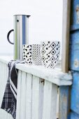 Mugs with black and white graphic patterns on balustrade