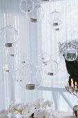 Aufgehängte Glaskugeln mit Teelichtern als schwebende Seifenblasen