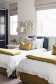 Twin beds and valances and scatter cushions in guest bedroom with lime-green accents