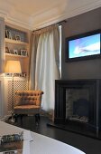 Gas fire, TV and easy chair in corner of living room