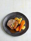 A slice of stuffed leg of lamb with carrots and potato gnocchi