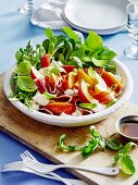 Gepfefferter Pfirsichsalat mit Rucola, Proscuitto, Mozzarella und Basilikum