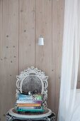 Shabby-chic chair with ornate backrest against board wall