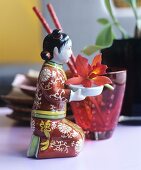 Small figurine of kneeling Chinese woman holding orchid flower