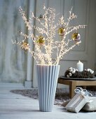 Dekozweige mit Weihnachtskugeln in eleganter Vase in Vintage-Ambiente