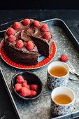 Chocolate cake with raspberries, sliced, with tea