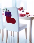 Felt Christmas stocking on backrest of white chair