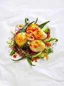 Scallops on parchment paper with chard, red cress and passion fruit