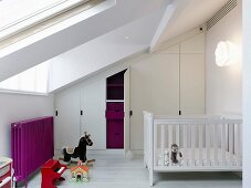 Attic nursery with fitted wardrobes under sloping ceiling