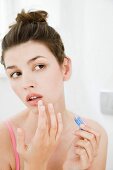 Woman applying cold sore ointment