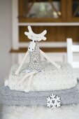 Fabric moose sat on stack of woollen blankets