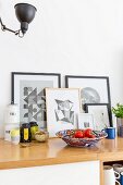 Graphical artworks leaning against wall behind kitchen utensils